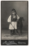 Dečak u šumadijskom odelu sa drvenim konjićem