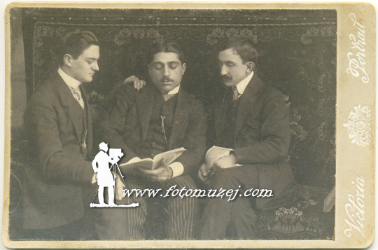 Trojica muškaraca čitaju knjigu (autor Mihajlo Antić)