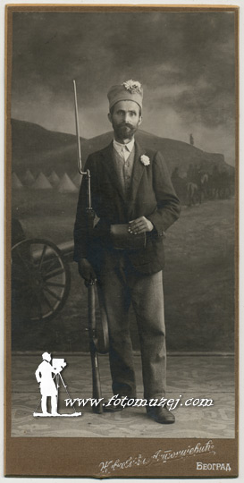 Muškarac sa puškom i cvetom u šajkači (autor Ivan Živković)